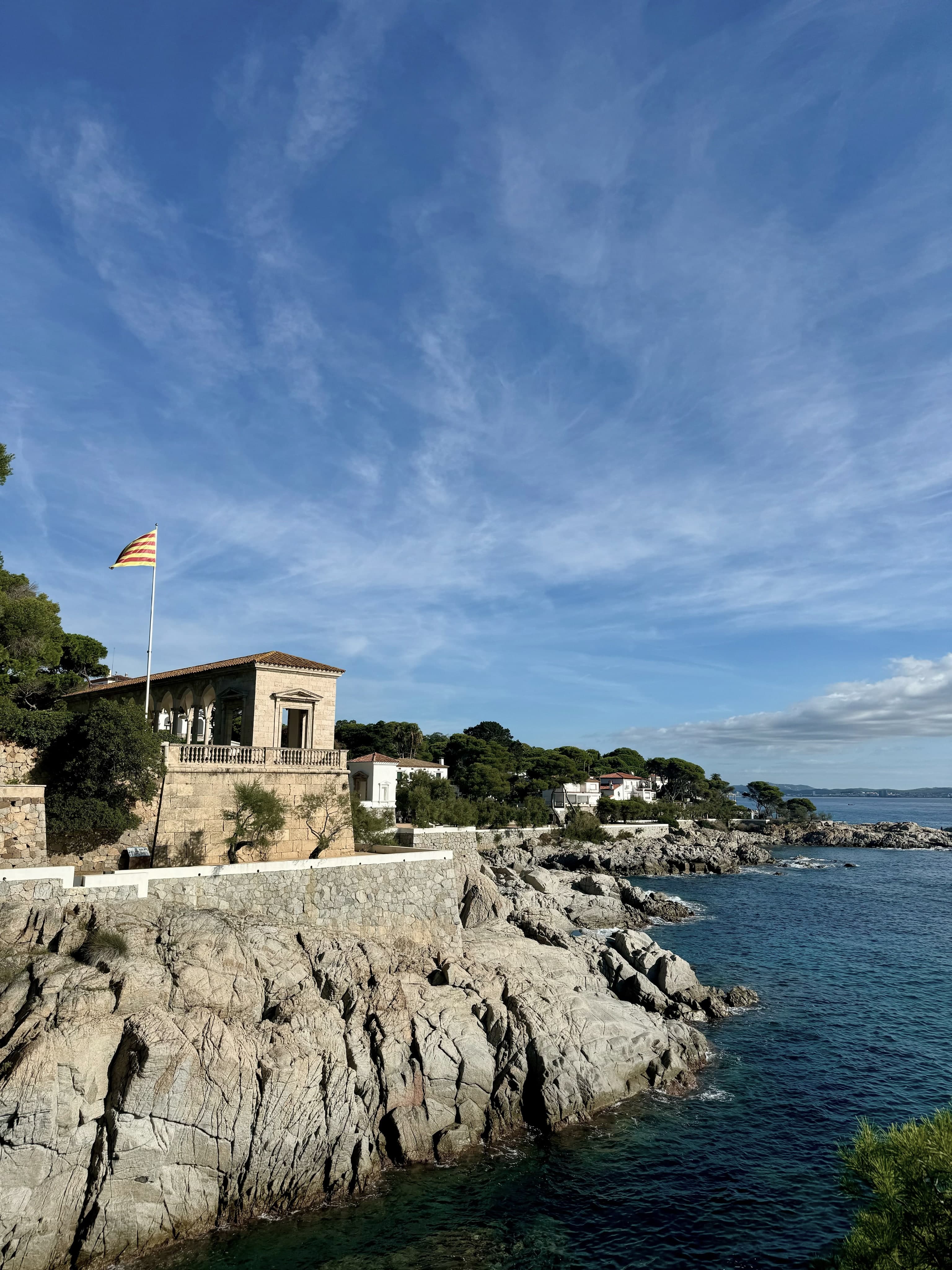Una casa señorial de S’Agaró con la bandera catalana, sobre los acantilados del camí de ronda