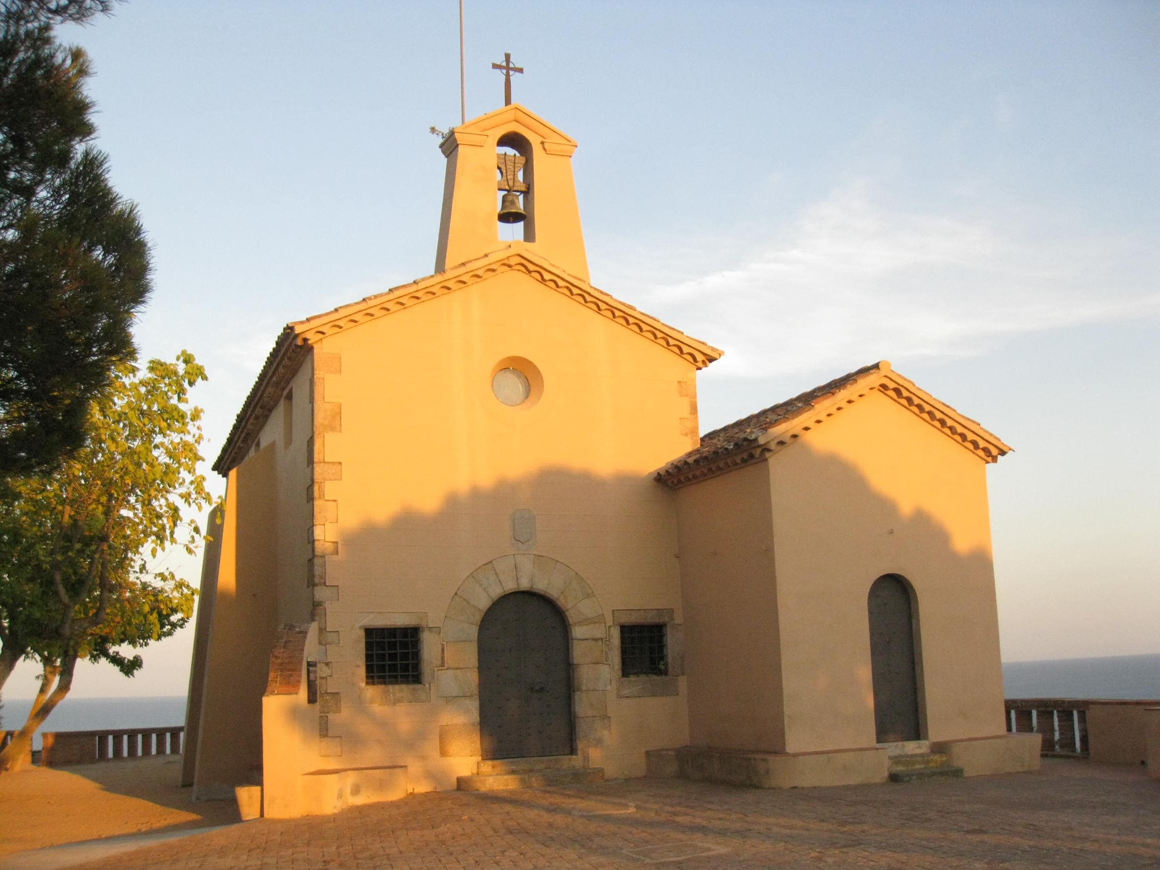 La Ermita de Sant Elm, capilla de fachada sencilla con espadaña, sobre el mar en Sant Feliu de Guíxols a la luz del atardecer