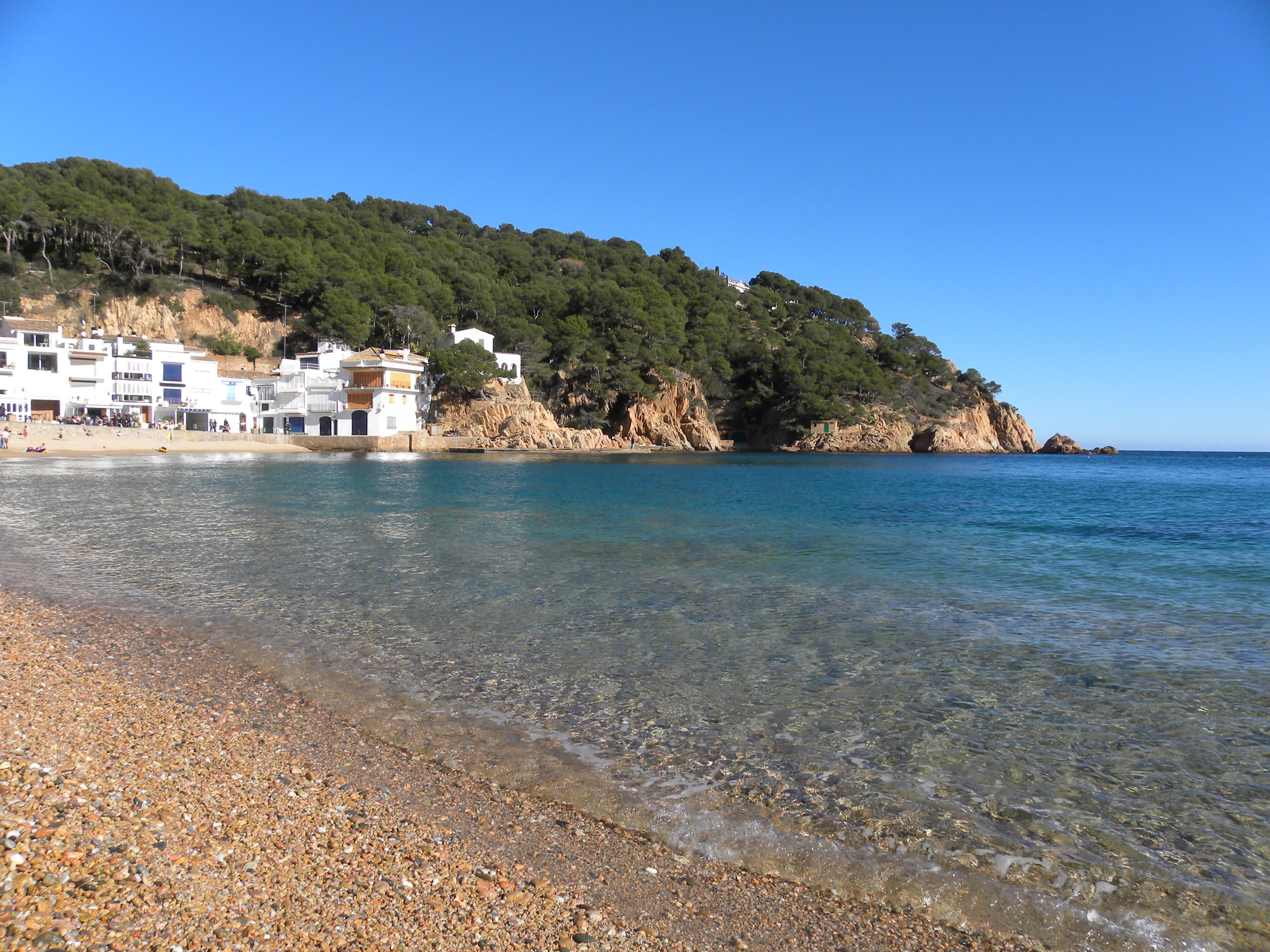 La Platja Gran de Tamariu, con las casas blancas dando directamente a la arena y el agua transparente de la cala