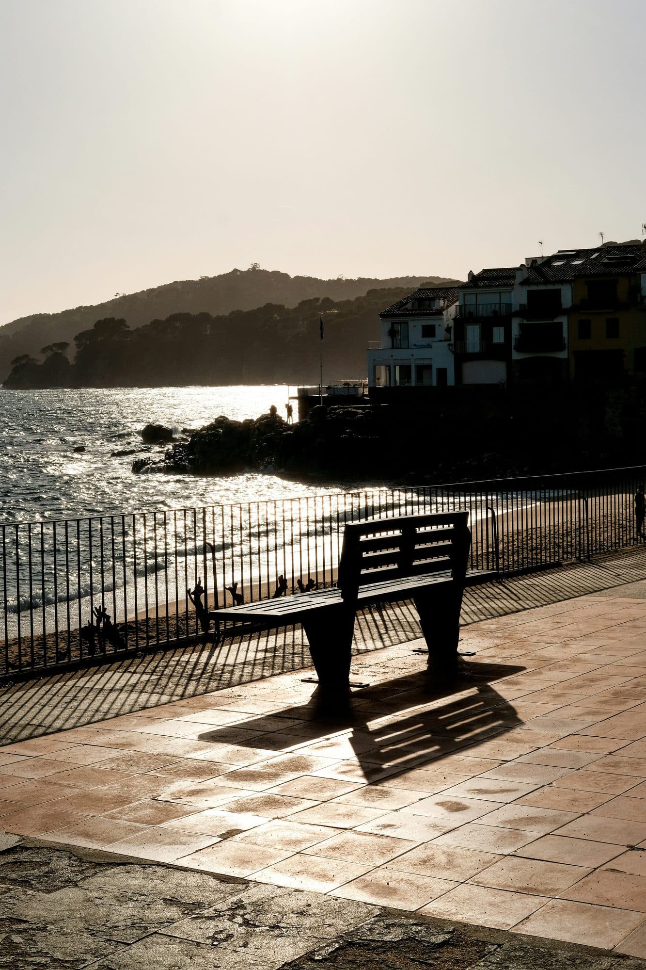 El paseo marítimo de Calella de Palafrugell al atardecer, con un banco frente al mar