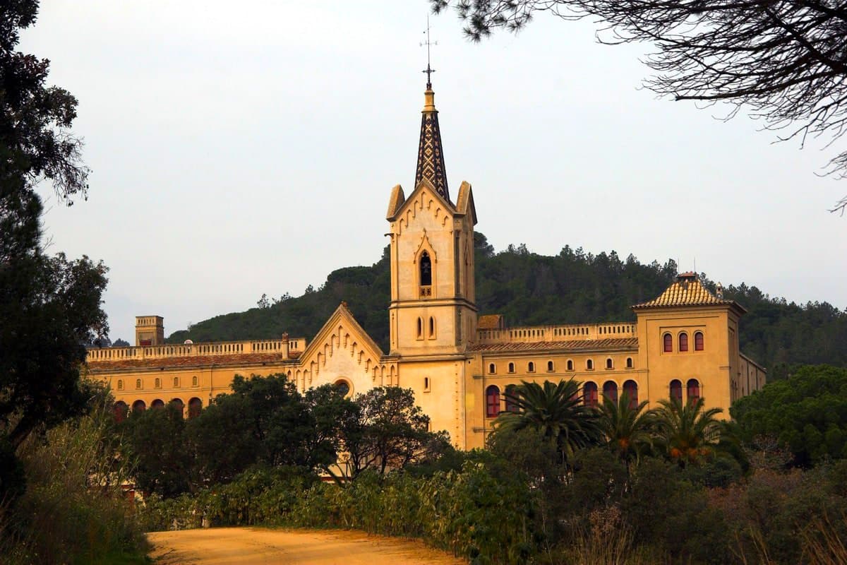 El santuario de Sant Pere del Bosc, con su torre neogótica, entre el bosque sobre Lloret de Mar