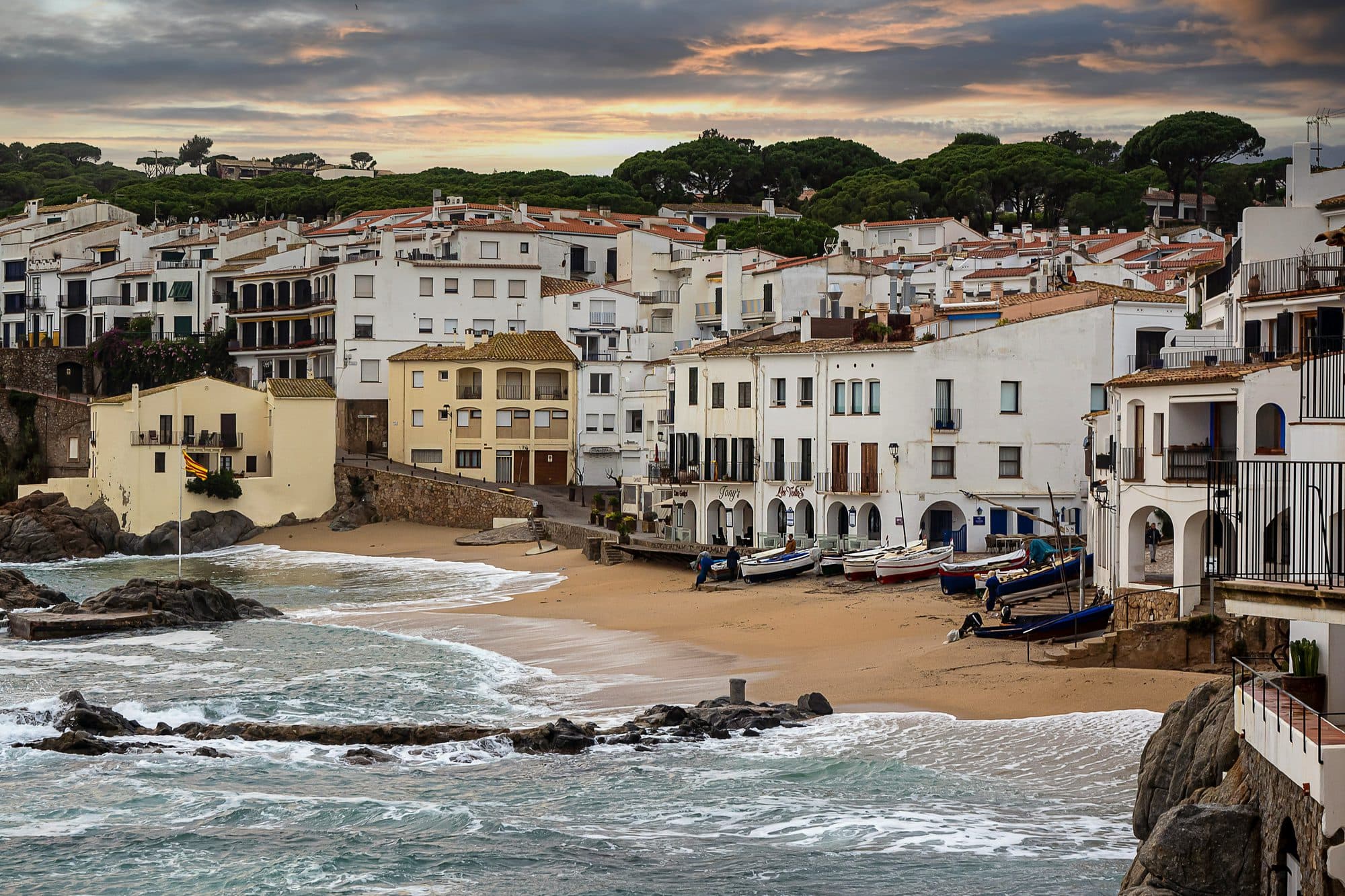 Playa y casas blancas de Calella de Palafrugell vistas desde las rocas de la orilla