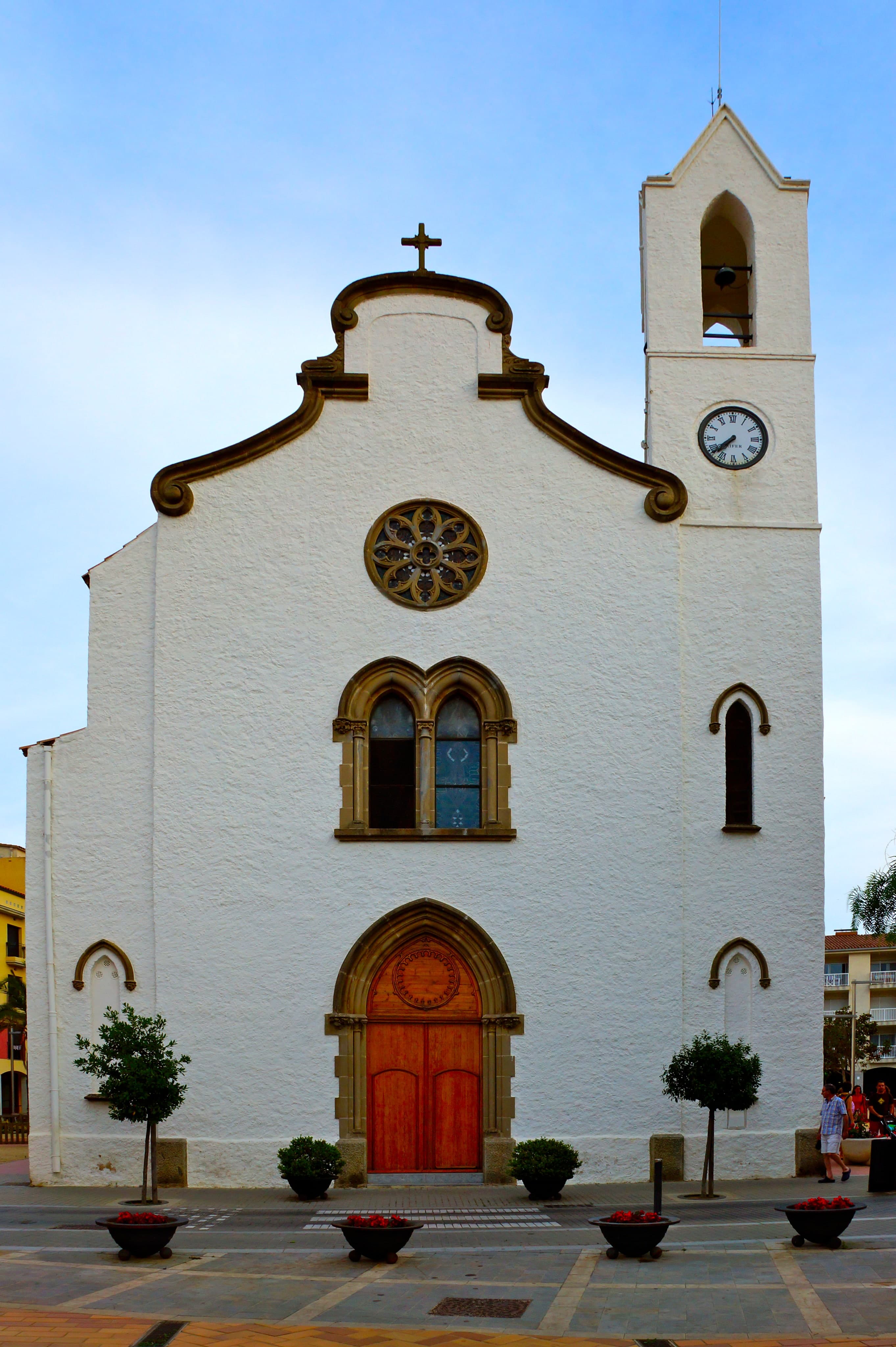 La fachada blanca y el campanario de la iglesia de Sant Antoni de Calonge, en la plaza del pueblo